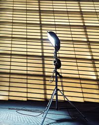 Close-up of electric lamp against crystal building. 