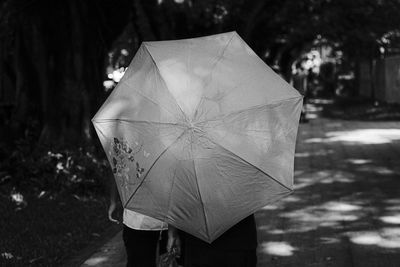 Close-up of person with umbrella standing on paper