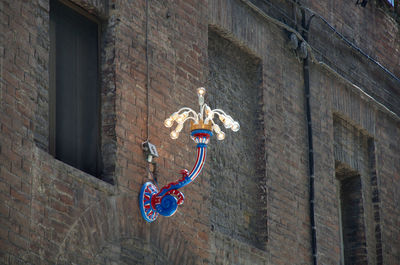 Low angle view of electric lamp hanging on wall