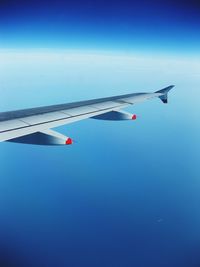 Airplane wing against clear blue sky