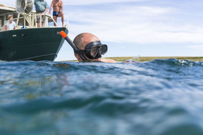 Man in boat on sea against sky