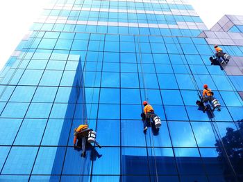 Low angle view of men working on building. cleaning worker