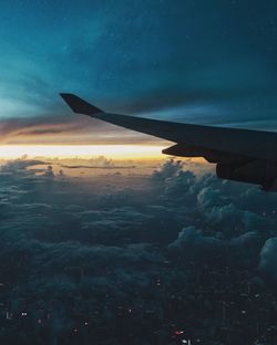 Airplane flying in sky at sunset