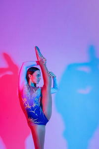 Rear view of woman with arms raised against blue sky