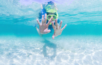 Low section of person swimming in pool