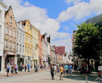 People on street in city against sky