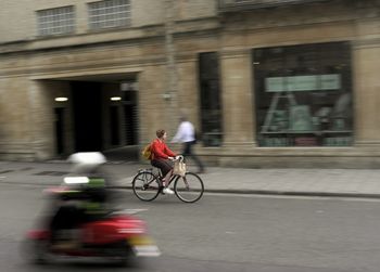 People riding bicycle on street in city