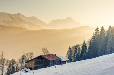 Houses on snow covered landscape against sky