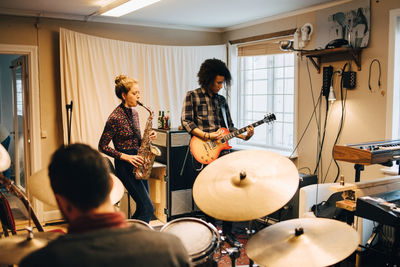 Friends playing musical instruments at studio