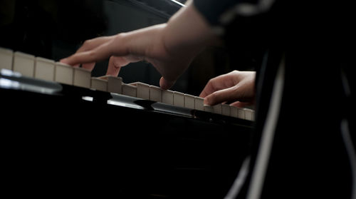 Midsection of person playing piano