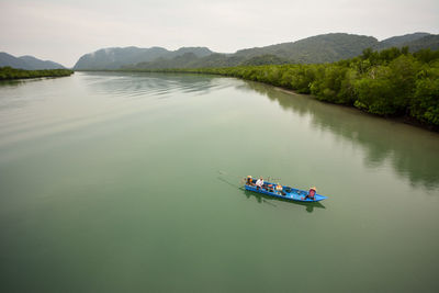High angle view of man rowing boat in lake against sky