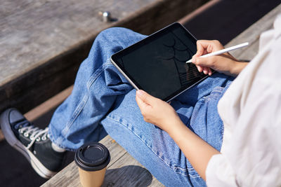 Midsection of man using digital tablet