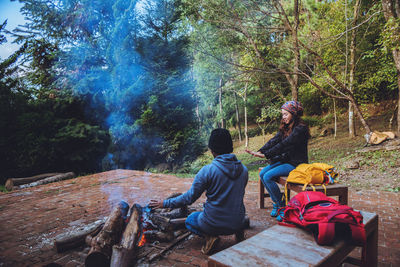 People sitting on sidewalk in forest