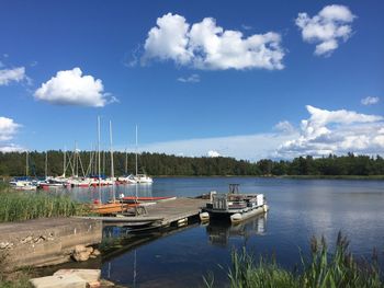 Sailboats moored in lake against sky