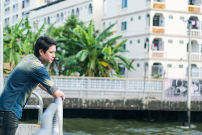 Side view of man in city against buildings