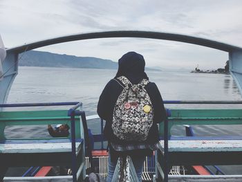 Rear view of woman on boat against sea