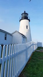 Low angle view of lighthouse by building against sky