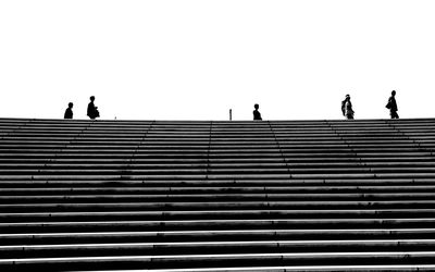 Low angle view of silhouette people walking on steps