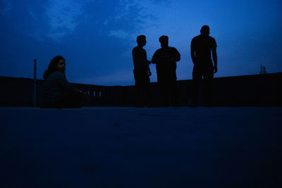 Silhouette people against blue sky