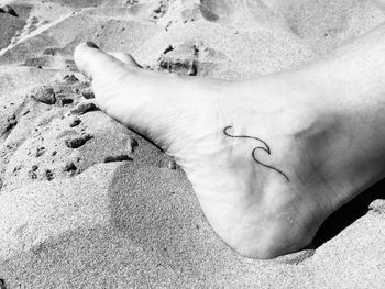 High angle view of human hand on sand