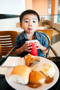 Portrait of boy eating food on table