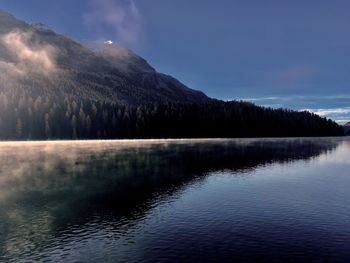 Scenic view of lake by mountain against sky