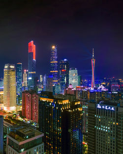 Illuminated buildings in city against sky at night