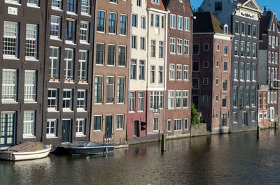 Canal by buildings in city
