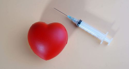 High angle view of red heart shape over white background