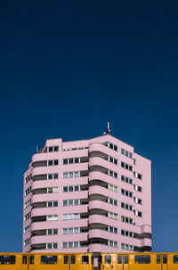 Low angle view of office building against blue sky