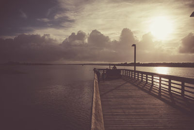 Pier on sea at sunset