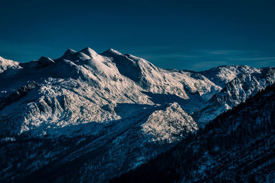 Scenic view of snowcapped mountains against clear blue sky