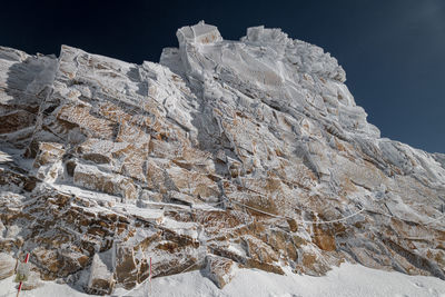 Low angle view of snowcapped mountain against sky