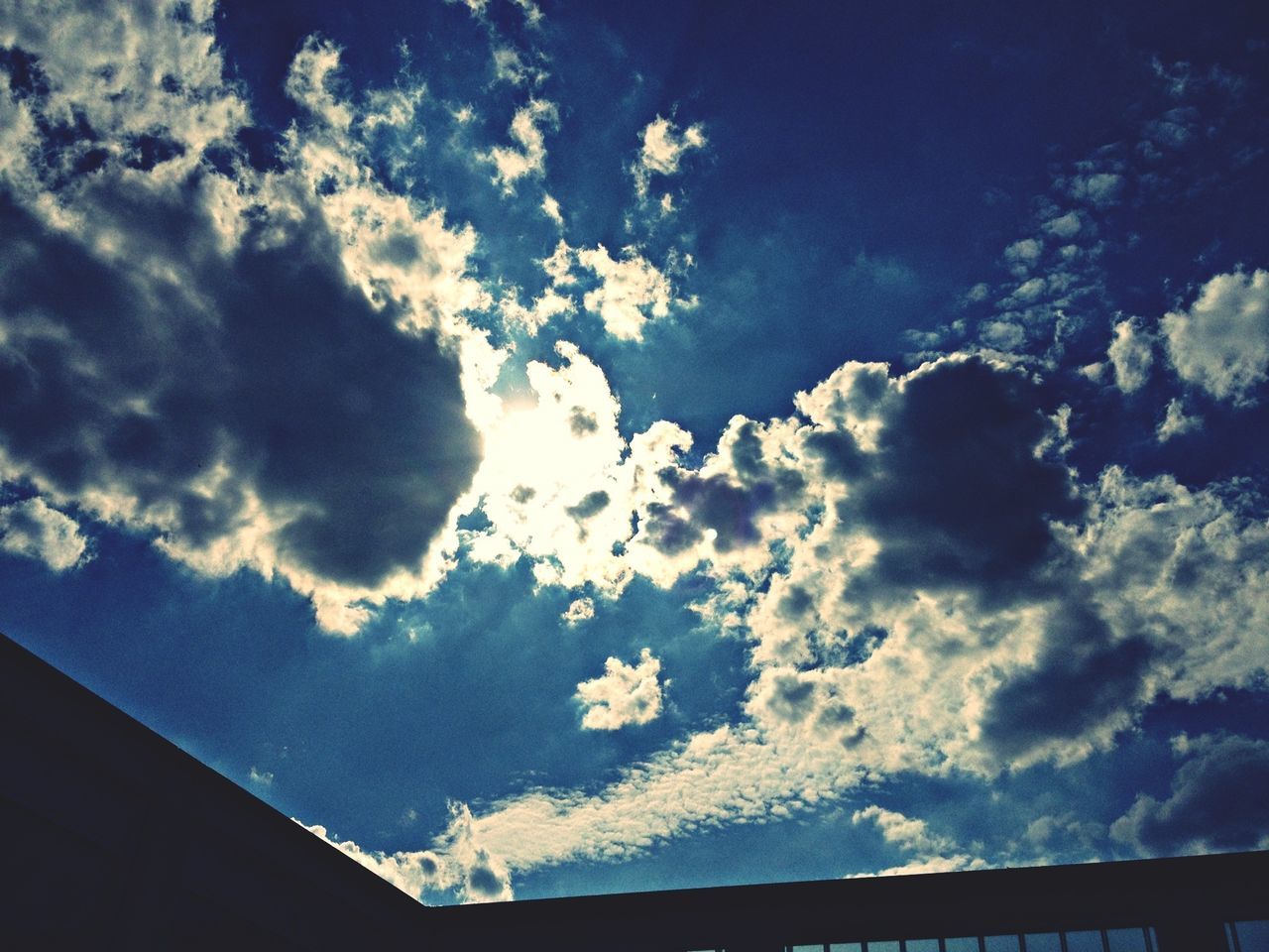 low angle view, sky, cloud - sky, blue, beauty in nature, nature, cloud, cloudy, silhouette, high section, scenics, tranquility, outdoors, no people, day, built structure, sunlight, tree, tranquil scene, cloudscape