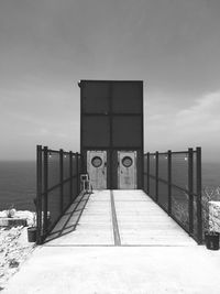 Closed metallic doors on pier against sky