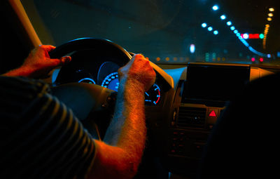 Midsection of man driving car at night