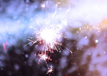 Close-up of illuminated sparkler during snowfall