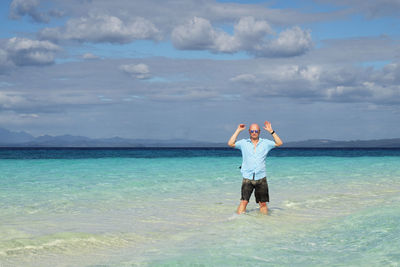 Portrait of man standing in sea shore against sky