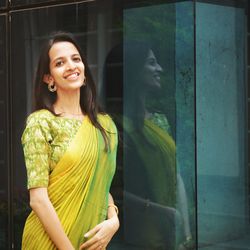 Portrait of a smiling young woman standing by window