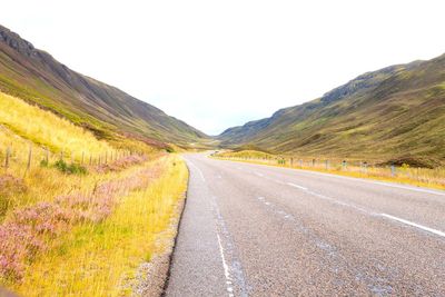 Empty road along countryside landscape