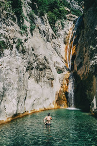 Man surfing on rock in water