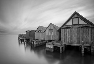 Houses by sea against sky