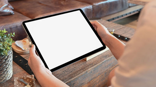 High angle view of person using mobile phone on table