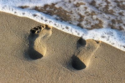 High angle view of footprints on sand at beach