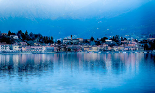 Scenic view of lake by buildings against sky