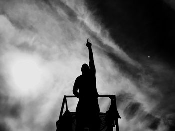 Low angle view of silhouette man standing against sky at dusk