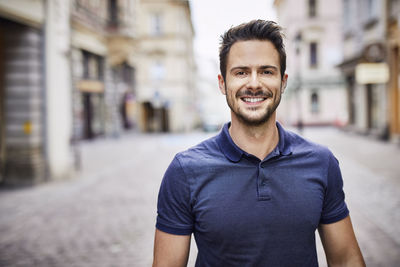 Smiling man standing on city street