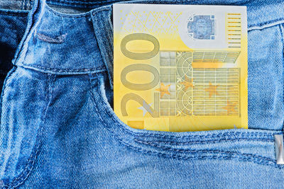 Close-up of paper currency in jeans pocket