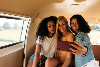 Young woman using smart phone while sitting in bus