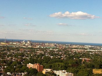 Cityscape by sea against sky